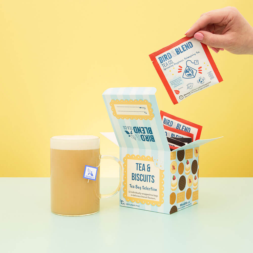 open tea and biscuit tea bag selection gift cube and hot malted milk tea latte in a mug