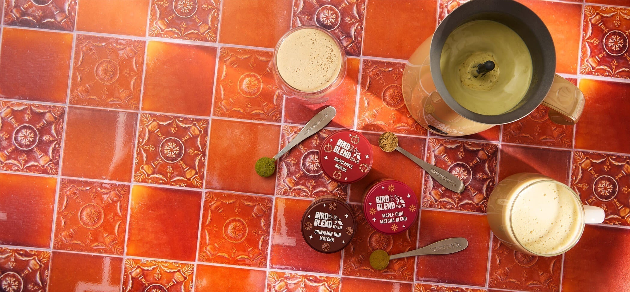 cinnamon bun matcha tea baked apple hojicha tea powder & maple chai matcha blend tin & spoons filled with matcha & tea powder & cups & mugs filled with matcha & bamboo matcha latte magic whisk filled with matcha