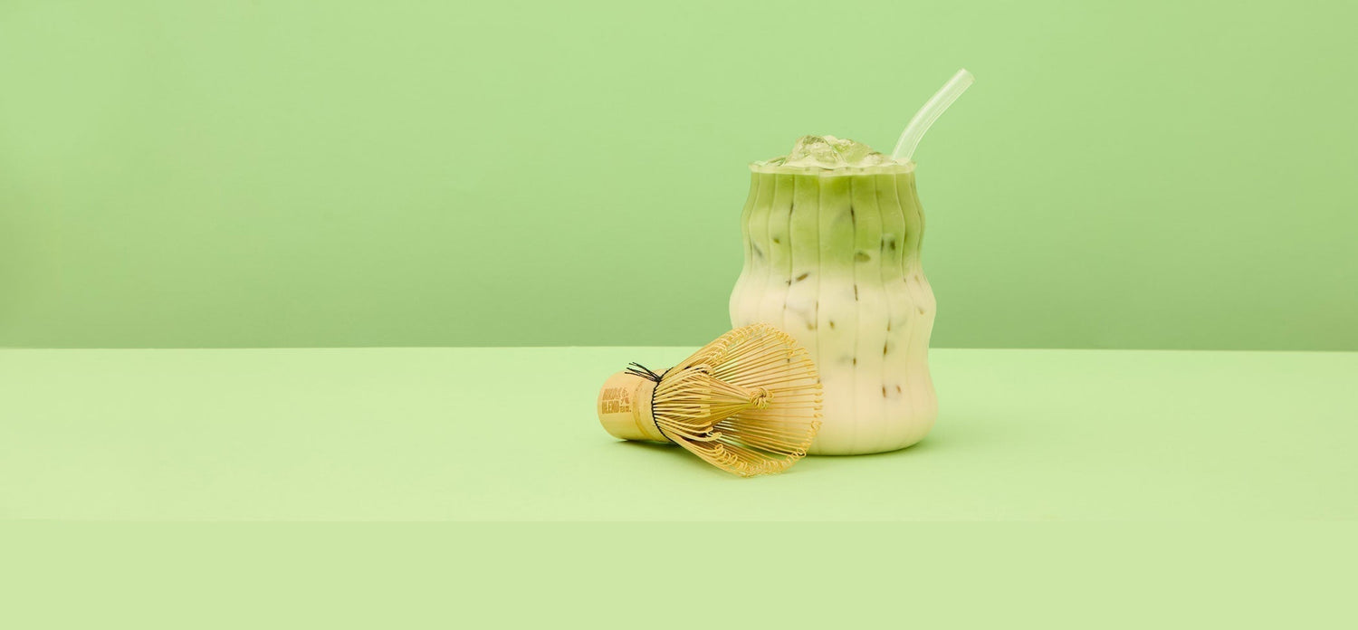 Iced matcha latte and traditional matcha whisk