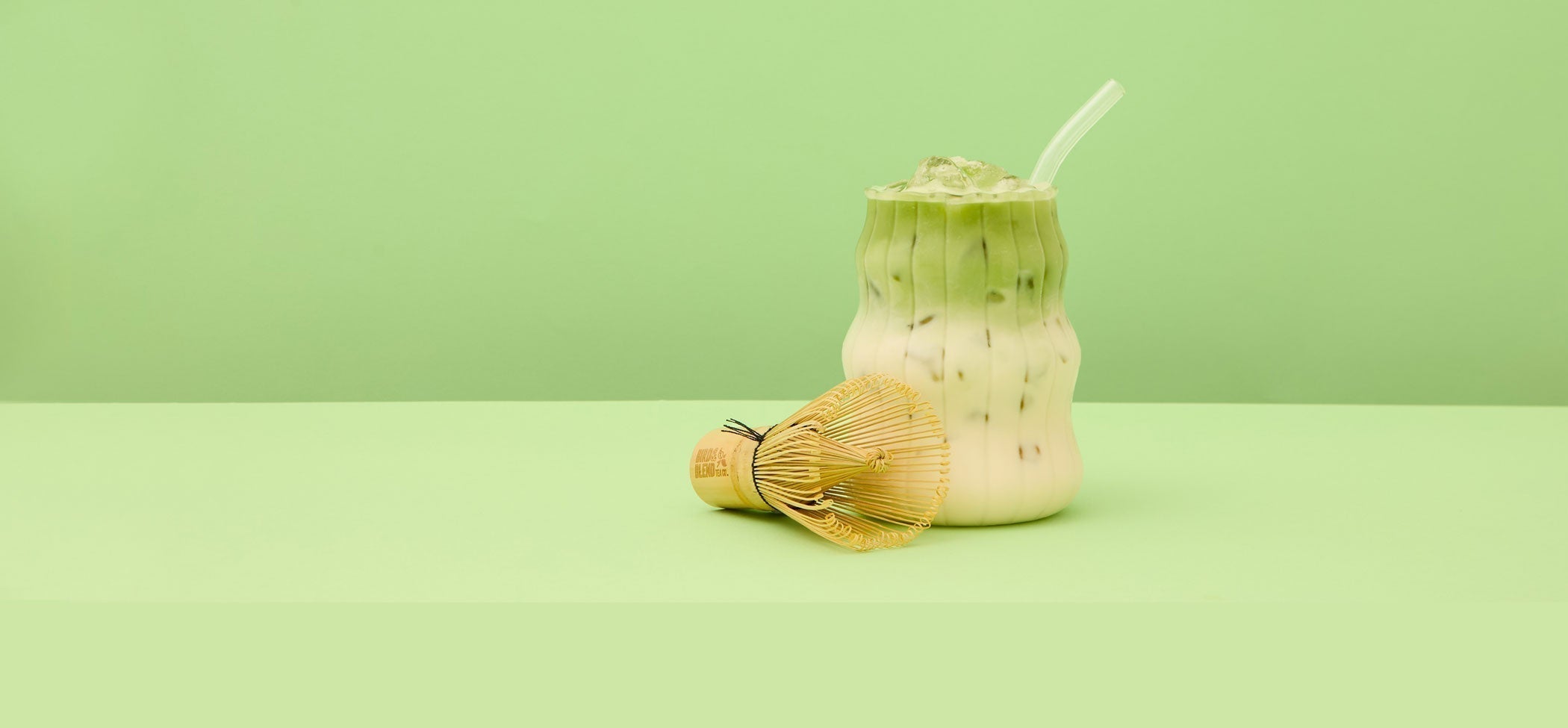 Iced matcha latte and traditional matcha whisk