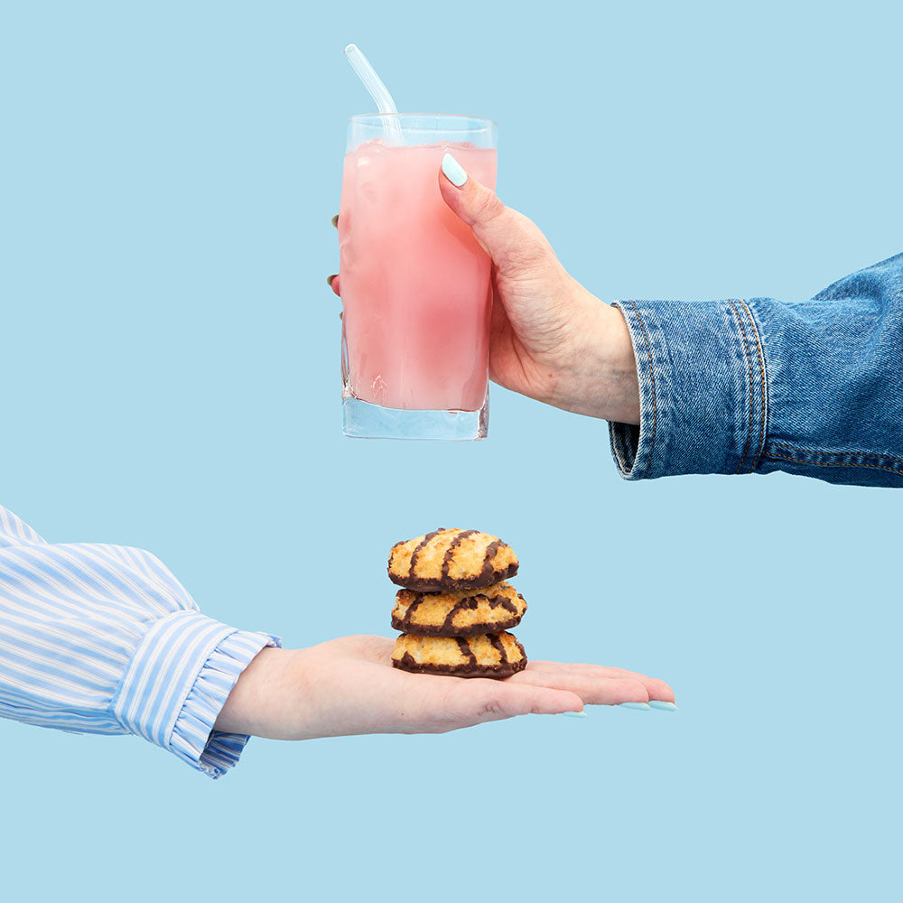 Holding coconut macaroon biscuit and holding coconut macaroon fruit tea