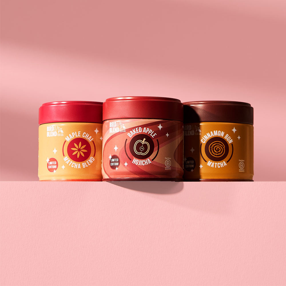 cinnamon bun matcha tin &amp; baked apple hojicha tin &amp; maple chai matcha blend tin on a pink table