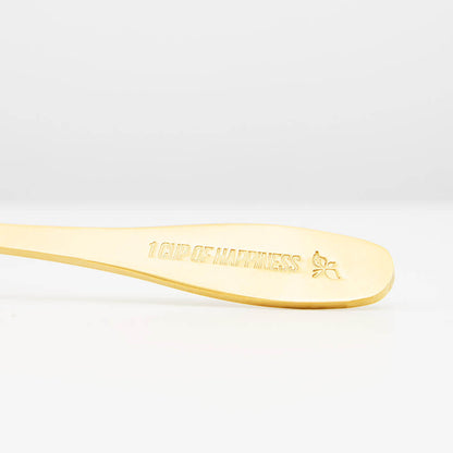gold tea spoon with loose leaf tea