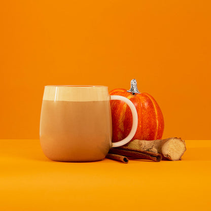 hot spiced pumpkin chai powder latte with pumpkin ginger &amp; cinnamon stick ingredients next to glass mug 